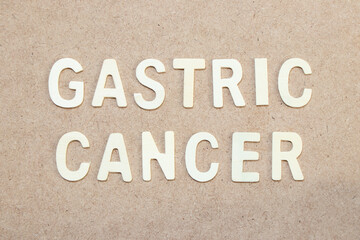 Fototapeta na wymiar Wood alphabet letter in word gastric cancer on wood background