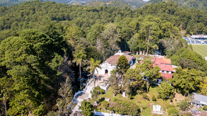 Fototapeta na wymiar Aerial view of a religious temple on top of a hill surrounded by trees.
