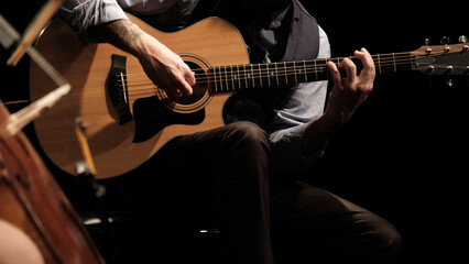Obraz na płótnie Canvas man playing guitar in the spotlight