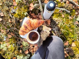 Piknik w lesie z kawą i croissant