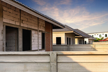 Unfinished single one storey house in a housing estate with morning sunlight