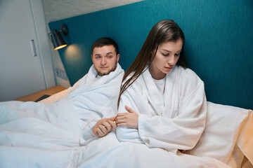 Fototapeta premium Beautiful woman in bad mood turned away from her husband