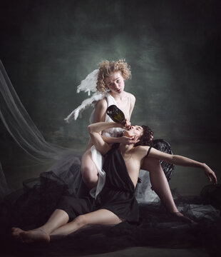 Alcohol addiction. Portrait of two women, angel and demon against dark, green, vintage background. Mental health, problems. Concept of history, , good and bad, creative photography, addiction