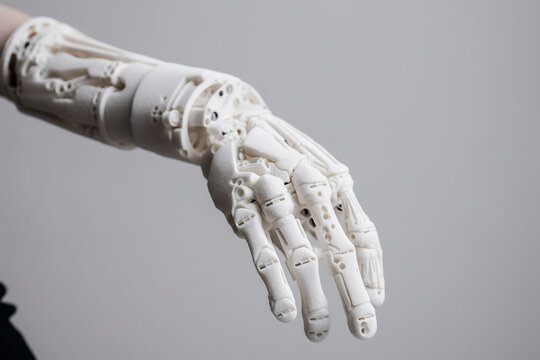 The arm of person holding a white artificial arm to their hand. Generative ai