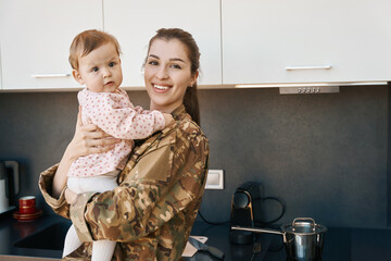 Happy young woman holding a little girl in her arms