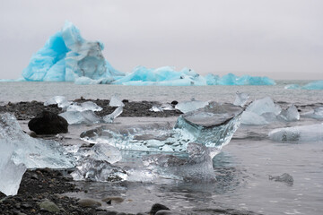 Blue Icebergs in Ocean Water. Glacier Ice Drift at Calm Water. Pure Ice Chunks from Melting Glacier. Icy Winter Landscape. Foggy Weather in Iceland.