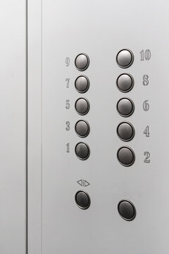 Gray elevator panel with silver buttons in a ten-story building