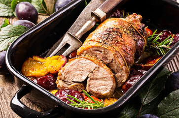 Traditional French barbecue lamb roast with vegetable and plums served as close-up in a rustic...