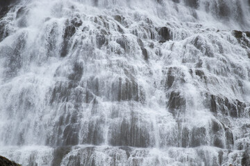 Fototapeta na wymiar Water Water Texture from Huge Waterfall. Powerful Mountain River Background. Beautiful Pure Nature in Iceland. Dynjandi Waterfall.