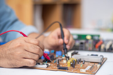 Fototapeta premium Technician using tool to measure circuit board, check and repair