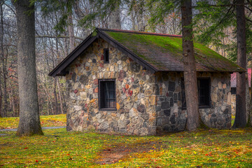A stone building at Chenango County State Park in the Spring. Old stone building with a roof covered in moss.