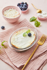 Delicious cottage cheese casserole in portioned glass forms with sour cream. Traditional Russian cuisine for breakfast - Zapekanka.