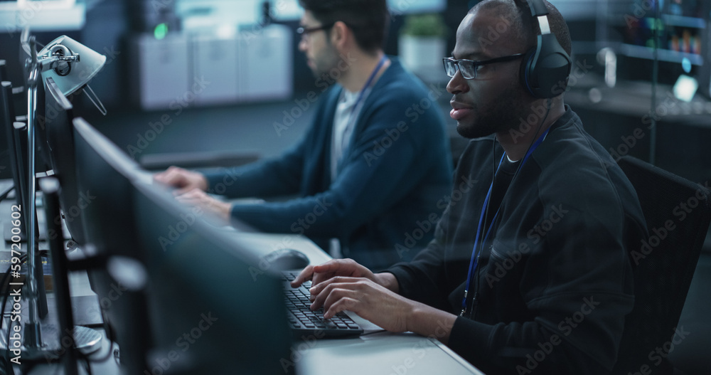 Aufkleber African American QA Engineer Finds and Fixes Bugs in a Product or Program Before the Launch, Collaborating and Talking with Colleague. Young Black Specialist Working in Advanced Technology Industry
