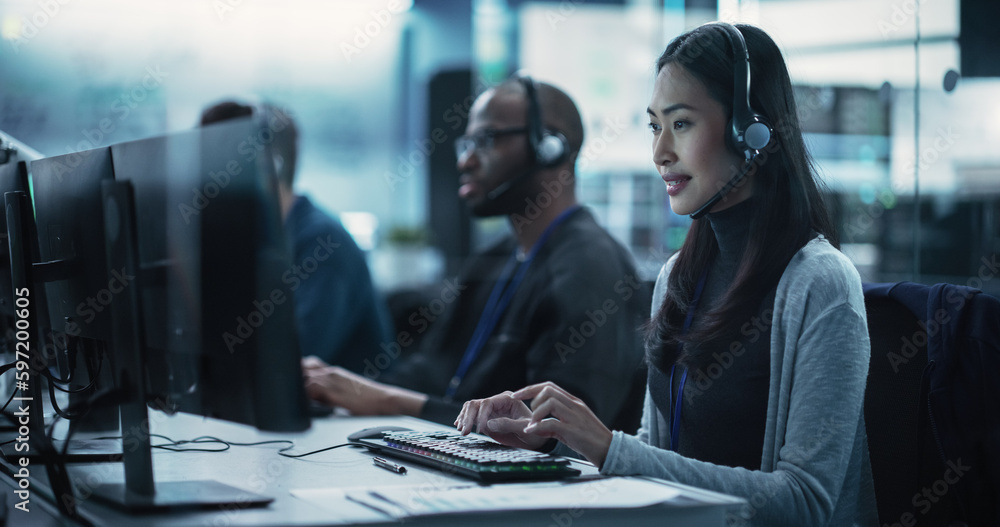 Fototapete Help Desk Specialist Answering a Call, Providing Technical Support to Client Experiencing Computer Hardware and Software Issues. Asian Female Using a Headset to Have a Conversation with a Tech Team