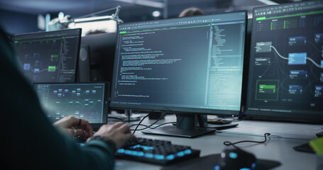 Close Up of a Software Developer Working on a Desktop Computer with Green Screen Mock Up Display. Specialist Typing on Keyboard, Coding and Implementing a New Technical Feature, Working in an Agency - obrazy, fototapety, plakaty