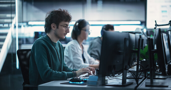 Young Creative Manager Using Computer, Writing a Project Plan for an Innovative Technological Internet Product Launch. Diverse Multicultural Team Working in a Startup Company