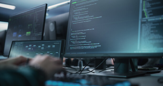 Close Up of a Software Developer Working on a Desktop Computer, Programming Code Running on Display. Specialist Typing on Keyboard, Coding and Implementing a Technical Feature