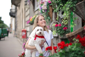 young woman with her dog at the entrance of a florist