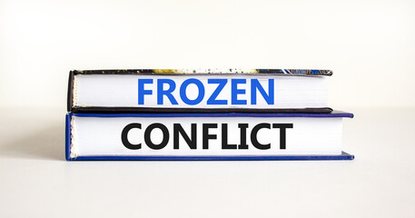 Frozen conflict symbol. Concept words Frozen conflict on beautiful books. Beautiful white table white background. Business and Frozen conflict concept. Copy space.