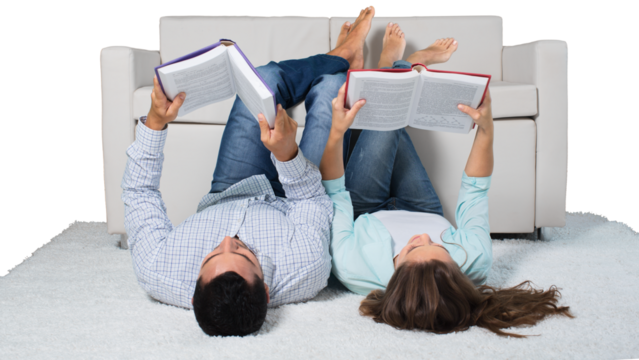 Young relaxed couple lying on the floor with book