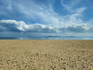 Fototapeta na wymiar Sandy sea beach and beautiful sky with white clouds