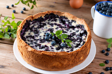 Homemade blueberry cheesecake with cottage cheese and sour cream on wooden table