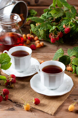 Tea with raspberry on a wooden table. Useful drink for health. Traditional medicine.