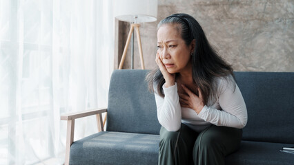 Mature woman feeling sad, asian elderly housewife anxiety depressed thinking senior chinese...
