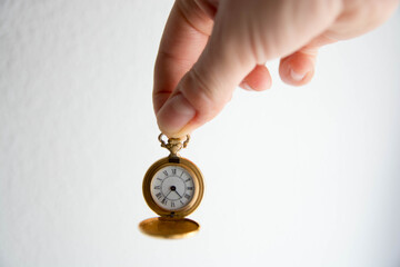 Mano sosteniendo reloj de bolsillo antiguo. Dorado. Copy space. Concepto tiempo.