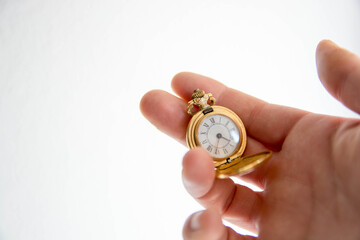 Mano sosteniendo reloj de bolsillo antiguo. Dorado. Copy space. Concepto tiempo.