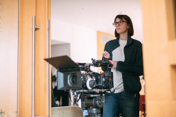 The director is a woman at work on the set. The director works with a group or with a playback...