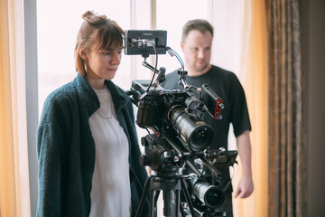 The director of photography is a woman behind a video camera on the set.  A professional...