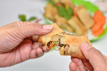 a woman's hand splits spring rolls close up