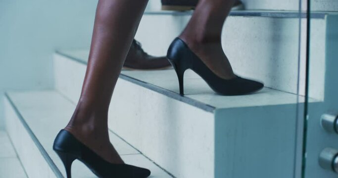Feet, stairs and business people walking in an office building climbing steps traveling to work or workplace. Legs, travel and person or employee with colleague walk, commute and on a mission