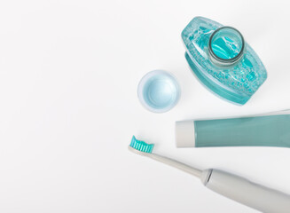 Electric toothbrush, toothpaste, mouthwash, dental floss and tongue cleaner isolated on white...