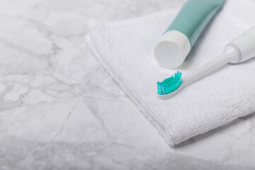 Electric toothbrush and toothpaste on a white towel on the background of the bathroom. Smart electric toothbrush. healthy teeth.Dentistry concept.