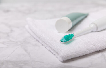 Electric toothbrush and toothpaste on a white towel on the background of the bathroom. Smart electric toothbrush. healthy teeth.Dentistry concept.