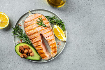 Dish grilled salmon steak with avocado and fresh vegetable salad. Keto diet concept healthy food, Healthy fats, clean eating for weight loss. top view