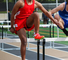 Boys running during a hurdle race on a track