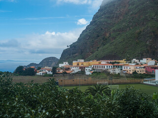 Fototapeta na wymiar View of old village Agulo with colorful traditional houses, terraced fields and mountain in green valley at north coast. Cloudy winter day. La Gomera, Canary Islands, Spain