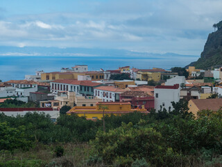 Fototapeta na wymiar View of old village Agulo with colorful traditional houses, terraced fields and ocean in green valley at north coast. Cloudy winter day. La Gomera, Canary Islands, Spain