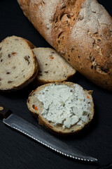 a slice of bread smeared with cottage cheese on a black background. Delicious and light breakfast