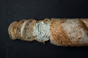 a slice of bread smeared with cottage cheese on a black background. Delicious and light breakfast