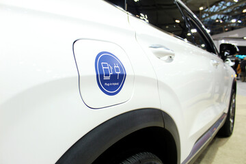 White hybrid car with "Plug in Hybrid" sticker on the charge port door.