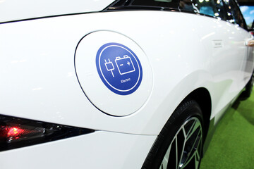 White electric car with "Electric" sticker on the charge port door.