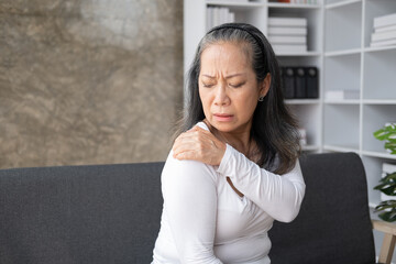 Middle aged asian woman suffers from shoulder joint pain or osteoporosis.