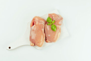 Raw fresh skinless chicken thigh meat with fresh herbs on a white background.Copy space.Food for retail.Ogranic food,healthy eating.Food concept.Top view.