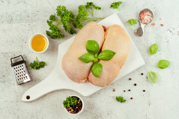 Chicken leg meat.Raw fresh chicken leg meat with skin on a light background with fresh herbs.Food...