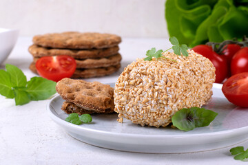 Caboc, Scottish soft cheese made of fat milk, in oat grains served on the plate