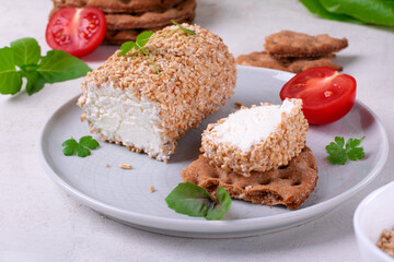 Caboc, Scottish soft cheese made of fat milk, in oat grains served on the plate